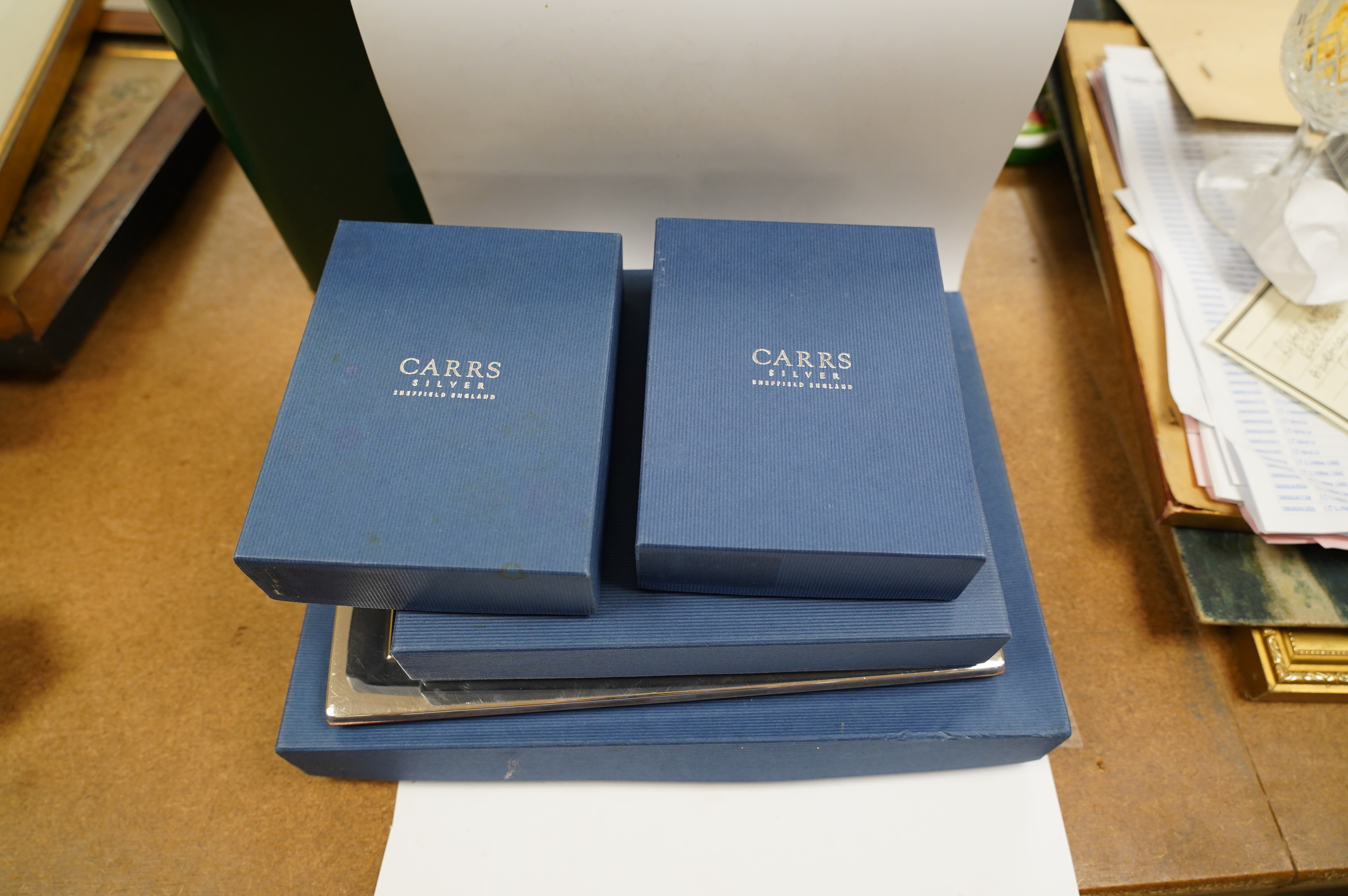 Four assorted modern Carr's of Sheffield, silver mounted photograph frames, three boxed, largest 24.2cm and a similar silver plated photograph frame, boxed. Condition - fair to good